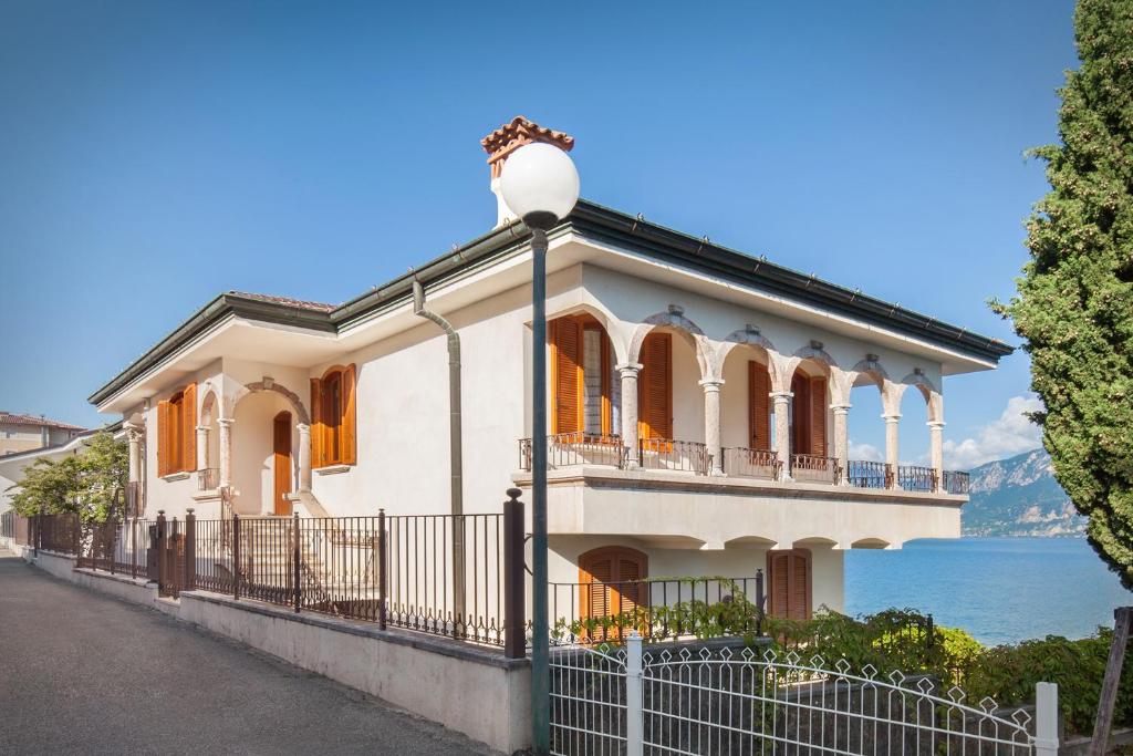 une grande maison blanche avec un éclairage de rue dans l'établissement Villa Francesca-Grande appartamento in riva al lago, à Brenzone