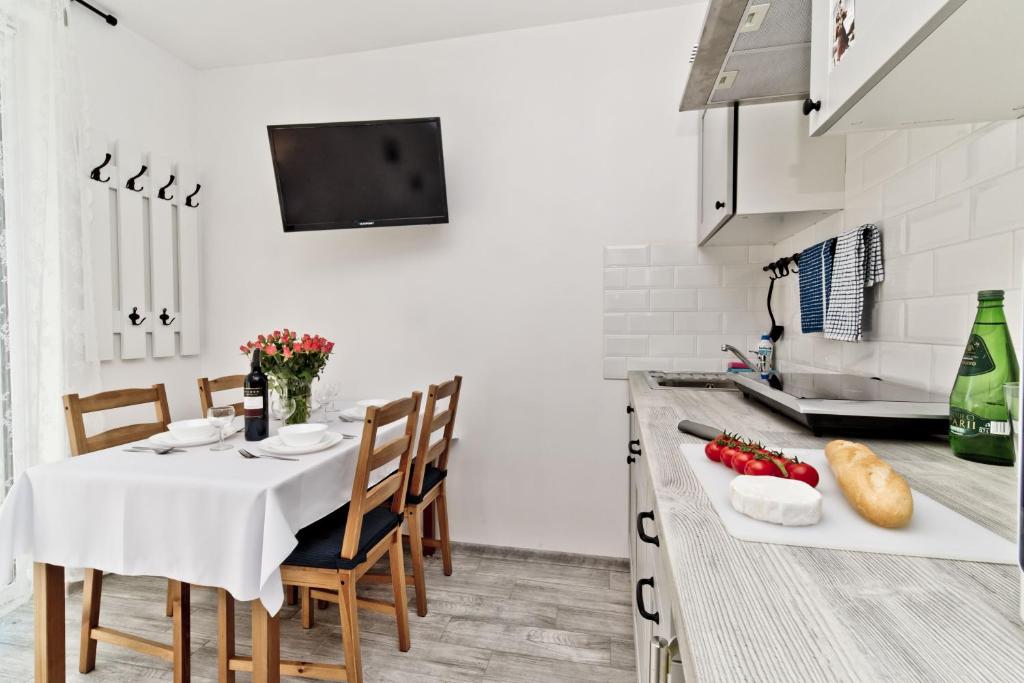 a kitchen with a table with a white table cloth at Apartamenty.in Chałupy Kaperska in Chałupy