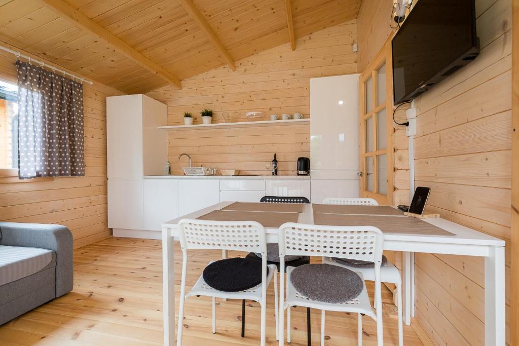 uma cozinha e sala de jantar com mesa e cadeiras em Domki z Papieru em Polańczyk