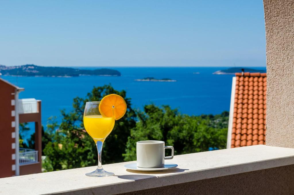 米利尼的住宿－Adriatic Sunny Apartments，一杯橙汁,在阳台上喝一杯