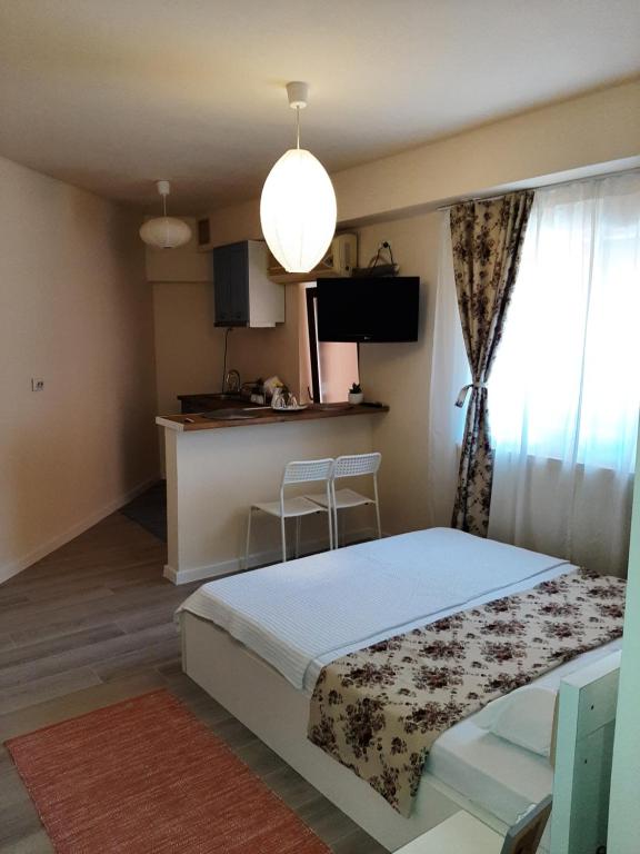 a small bedroom with a bed and a kitchen at Casa Flamingo in Craiova