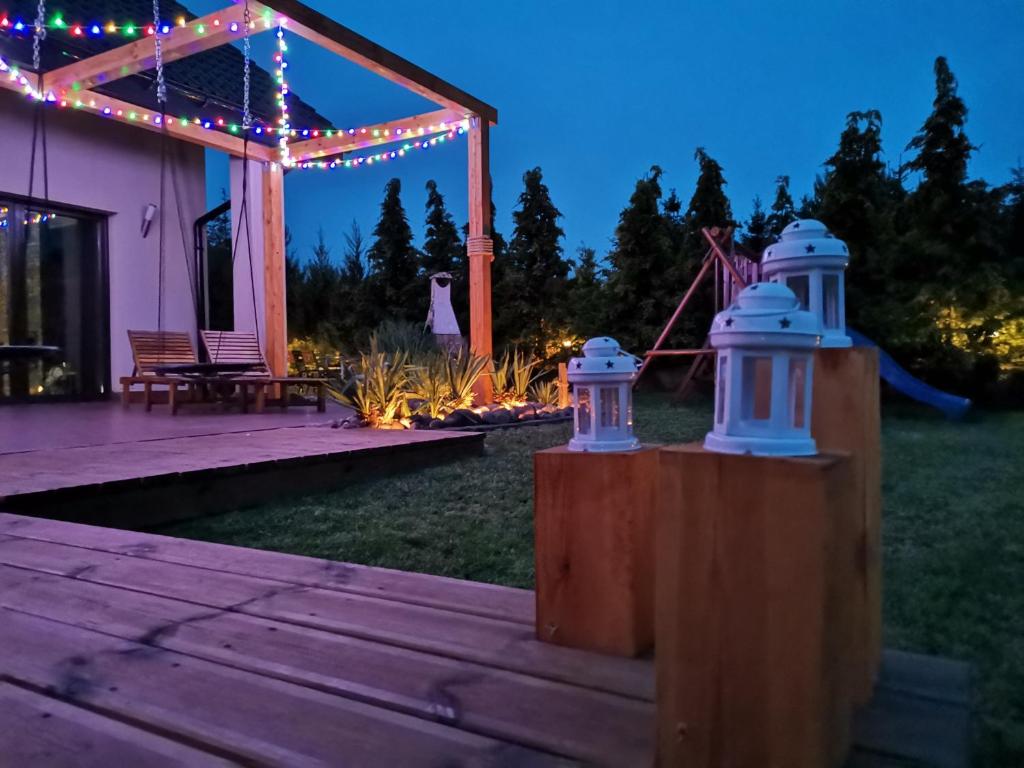 a backyard with a deck with a pergola and lights at Habibispa z JACUZZI pod chmurką MEGA OFERTA na stronie in Stare Juchy