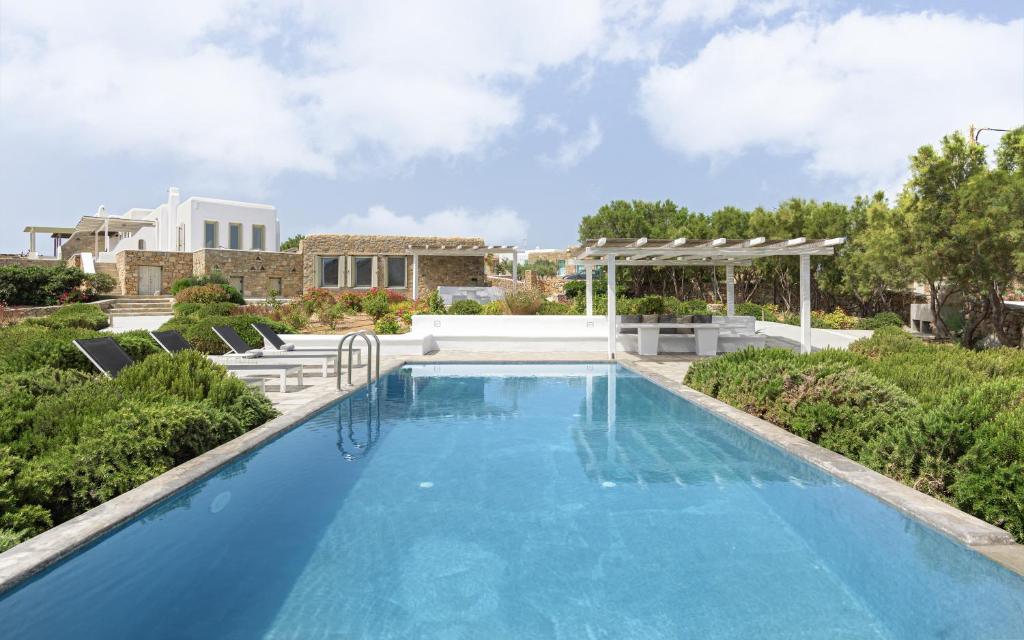 a large swimming pool with blue water at Mykonos Unique Villas in Kalafatis