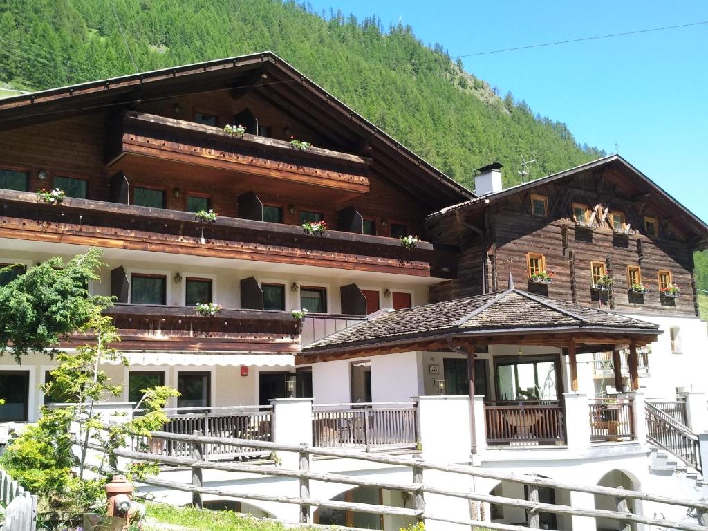 a large building with a mountain in the background at Hotel Rainhof in Senales