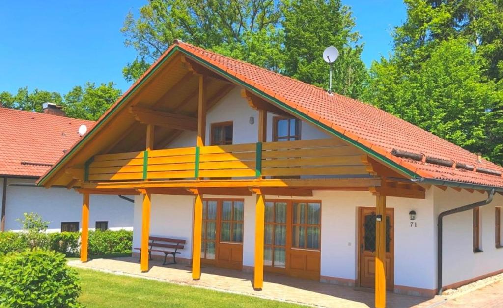 a house with a red roof and a bench at Feriendorf Büchelberg in Windorf