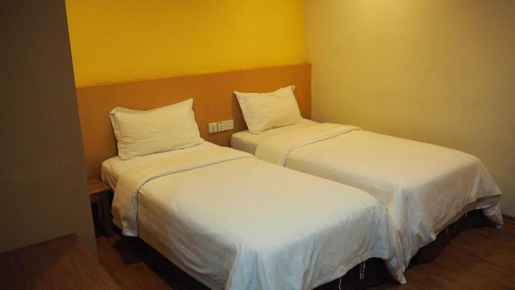 Postel nebo postele na pokoji v ubytování 906 Hotel Melaka Raya