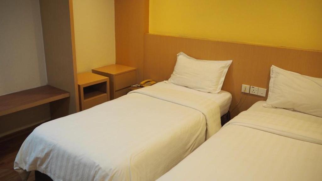 Postel nebo postele na pokoji v ubytování 906 Hotel Melaka Raya