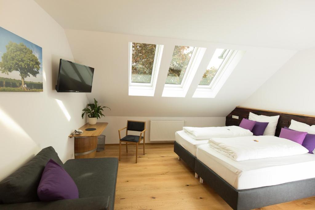 um quarto com 2 camas e almofadas roxas em IBY-LEHRNER WEIN-GUT und WEIN-Träumerei em Horitschon