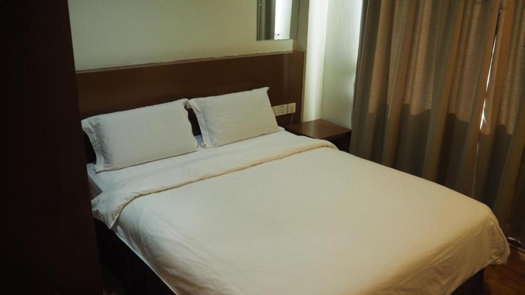 Postel nebo postele na pokoji v ubytování 906 Hotel Melaka Raya