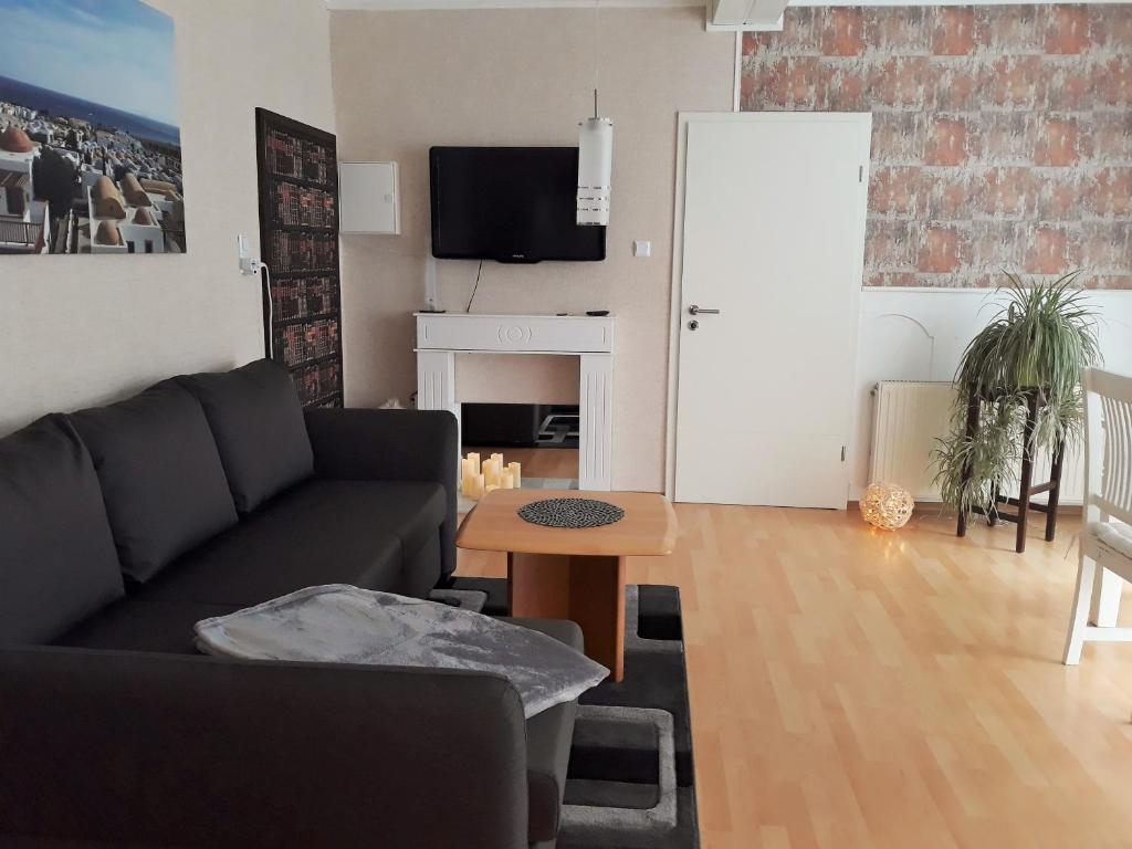 uma sala de estar com um sofá e uma mesa em Ferienwohnung FLAIR em Zella-Mehlis