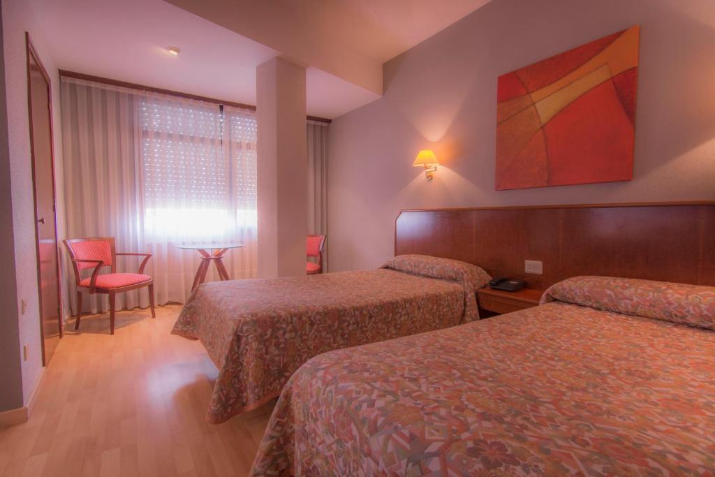 a hotel room with two beds and a window at Hotel Unzaga Plaza in Éibar