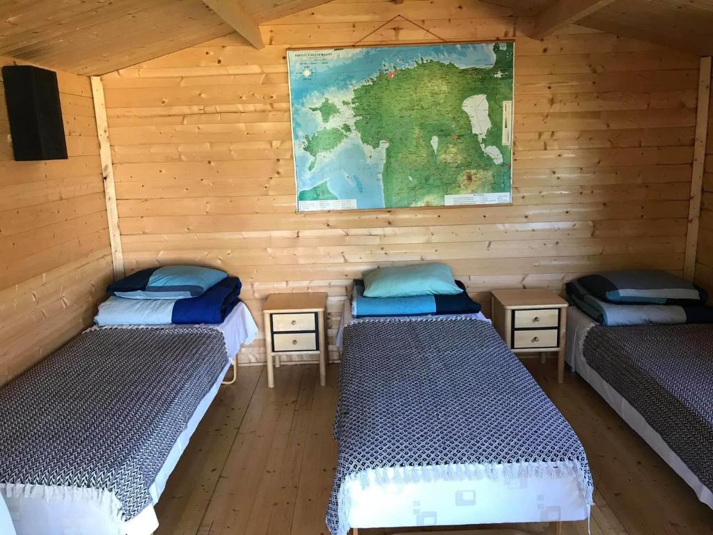 a room with three beds and a map on the wall at Sillaotsa camp in Paide