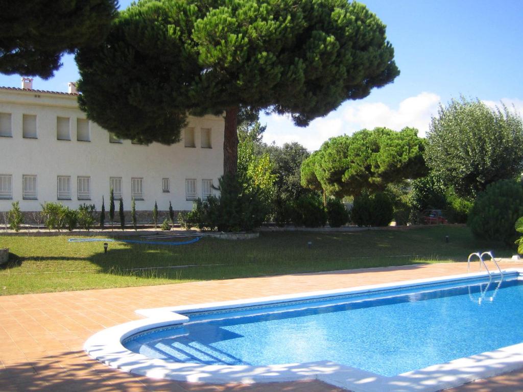 une piscine en face d'un grand bâtiment dans l'établissement Hostal Los Pinares, à Lloret de Mar