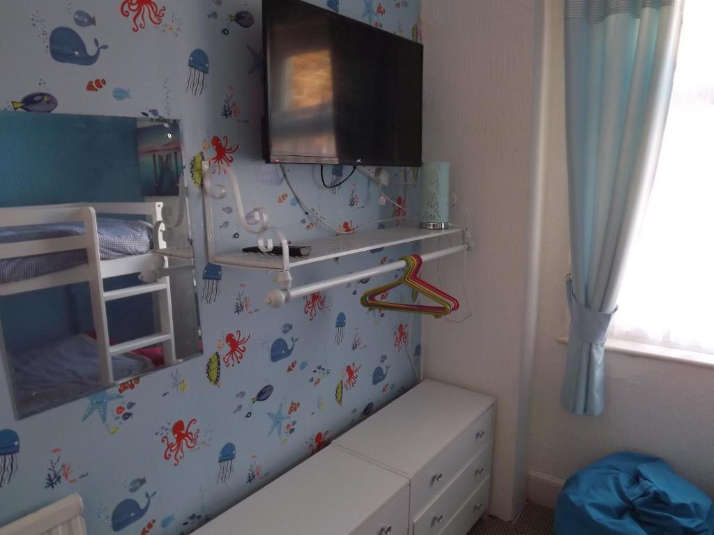 a childs bedroom with a crib and a mirror at The Chequers in Great Yarmouth