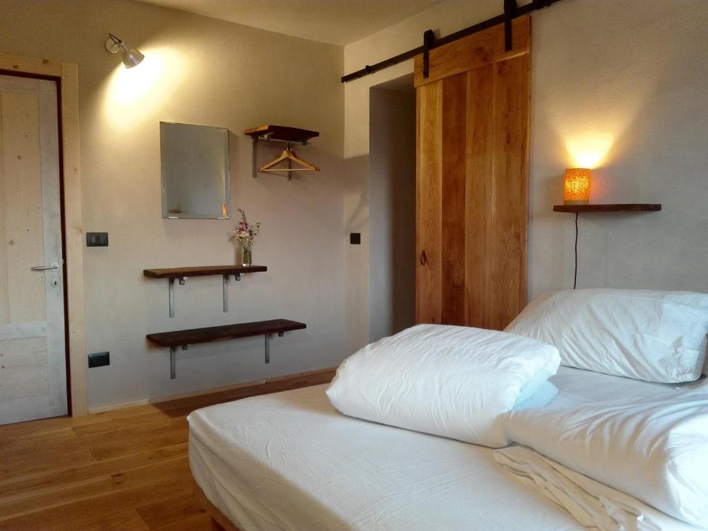 ein Schlafzimmer mit einem weißen Bett und Regalen an der Wand in der Unterkunft Le Spine B&B sulla Via Francigena in Berceto