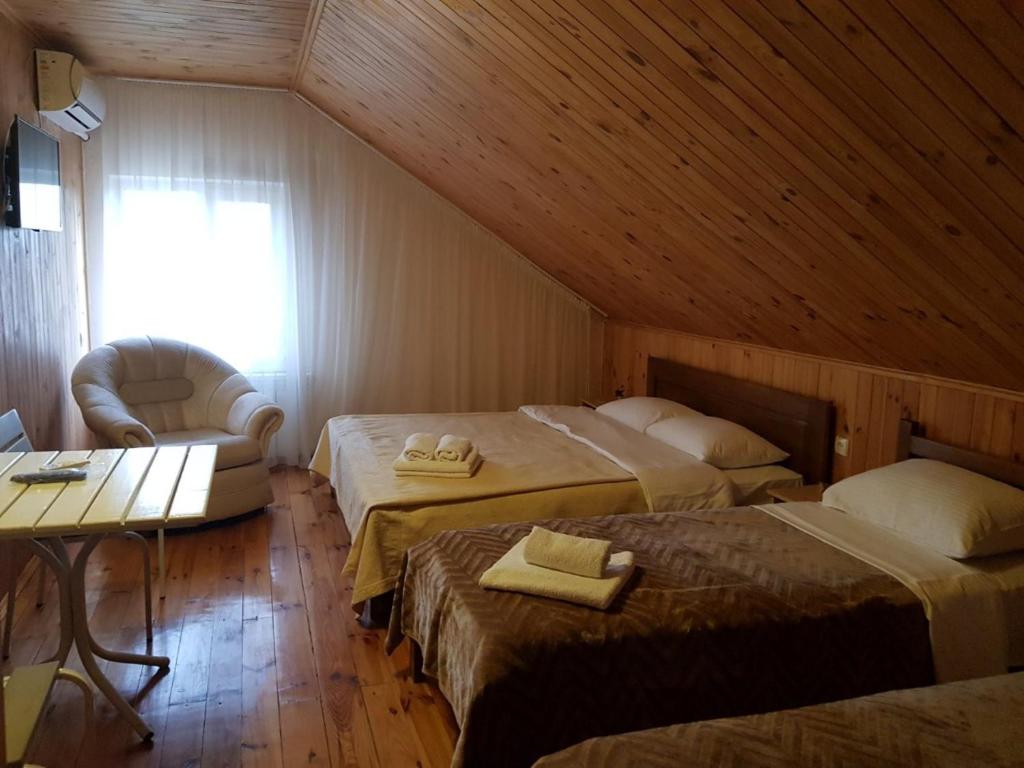a attic room with two beds and a chair and a table at Барокко in Bilhorod-Dnistrovskyi