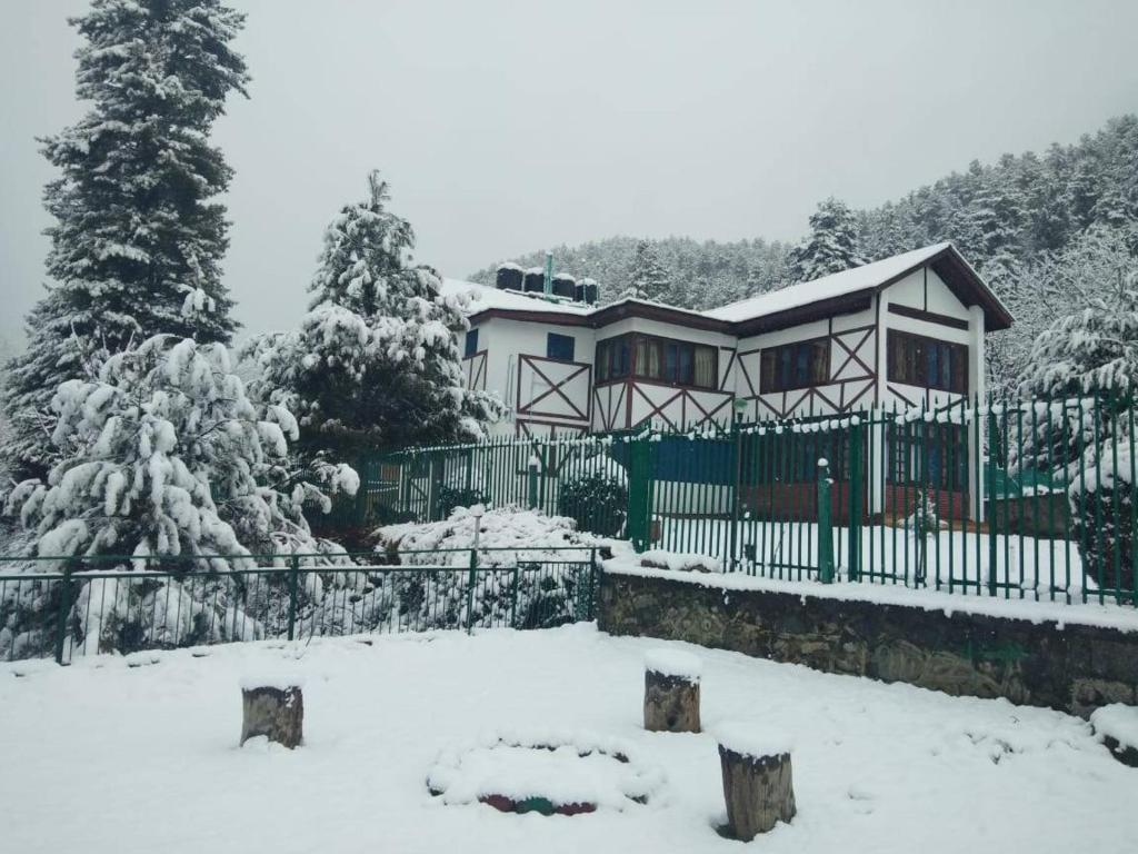 a house covered in snow with a fence at Walisons Peace Resort in Pahalgām