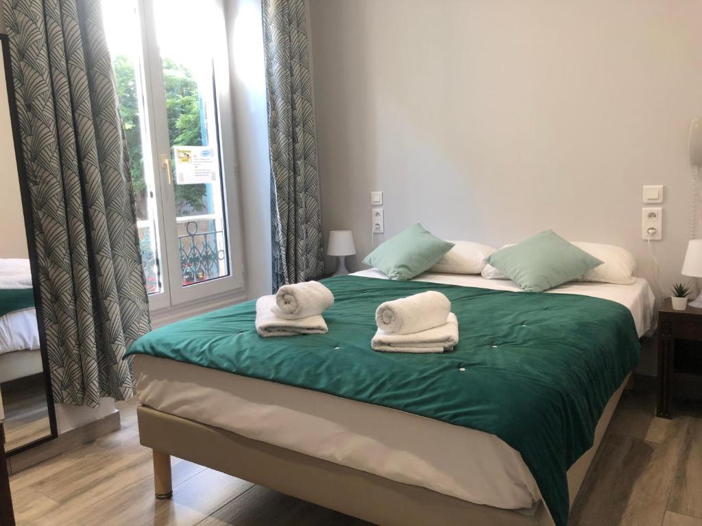 a bedroom with a bed with towels on it at Hotel le Nice Etoile in Nice