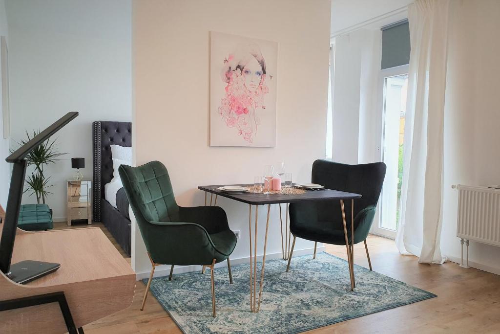 een eetkamer met een tafel en vier stoelen bij PB Ferienwohnungen - FeWo 4 - Stilvoll eingerichtetes Studio im Herzen Senftenbergs in Senftenberg