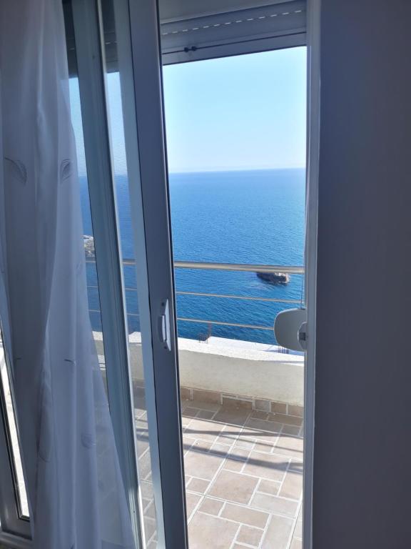 uma porta para uma varanda com vista para o oceano em Apartments South em Ulcinj