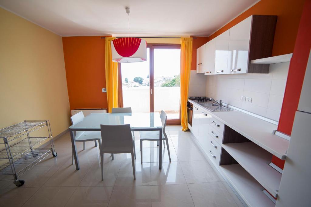 uma cozinha com mesa e cadeiras num quarto em Arianna Apartments em Pescara