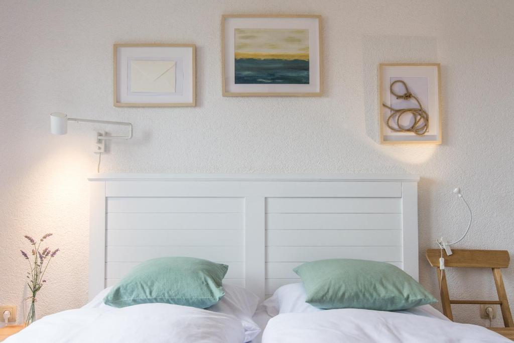 a bedroom with a white headboard and two green pillows at Apartments Makii in Biograd na Moru