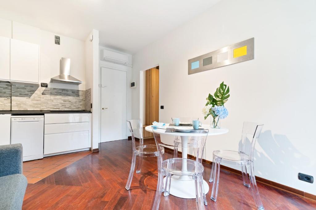 Una cocina y un comedor con una mesa y sillas blancas. en A pochi passi da Prato della Valle Apartment, en Padua