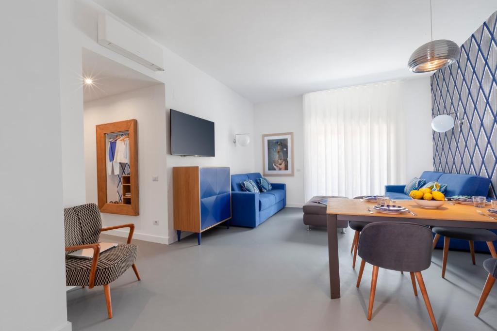 a living room with a table and a blue couch at Luxury Design Home & Jacuzzi in Heart of Sorrento in Sorrento