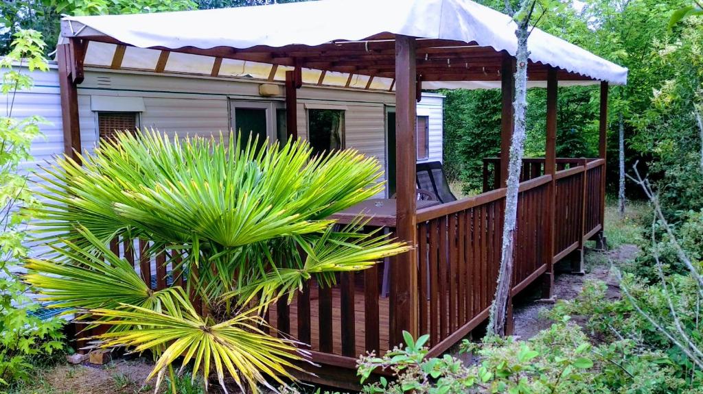 - un kiosque avec un parasol sur une terrasse dans l'établissement Camping baradis, à Commensacq