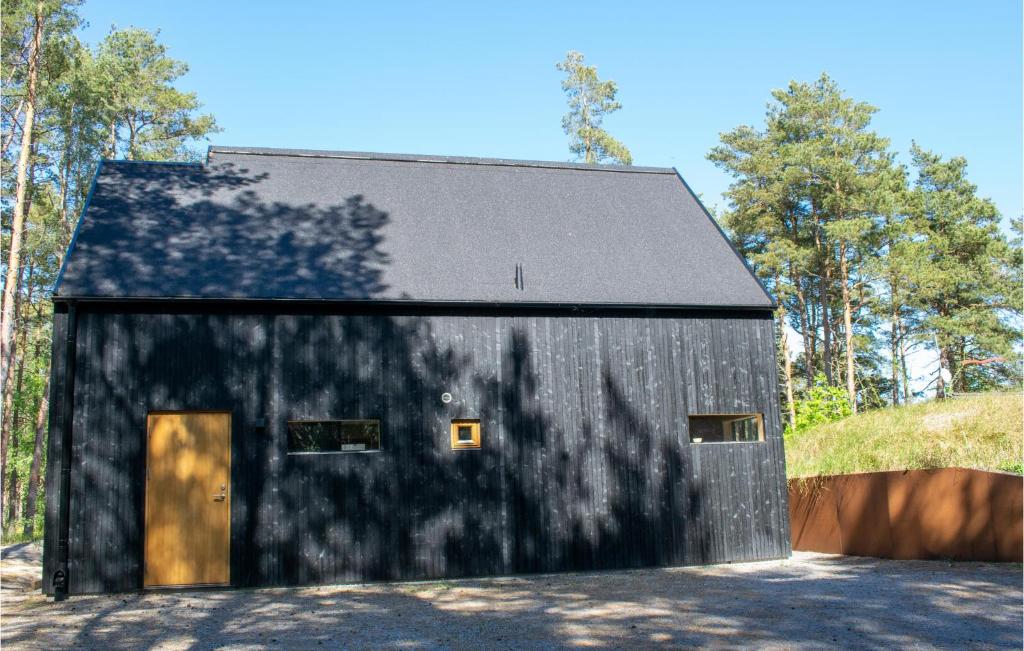 un granero negro con techo negro en Lovely Home In Borrby With Kitchen, en Borrby