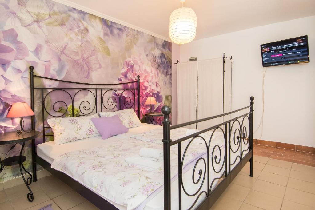 a bedroom with a bed with a painting on the wall at Apartments & Rooms Darrer in Poreč