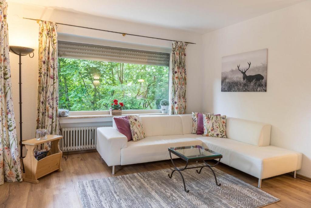 ein Wohnzimmer mit einem weißen Sofa und einem Fenster in der Unterkunft Ferienwohnung Lilly in Garmisch