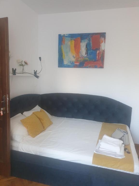 een bed in een slaapkamer met een schilderij aan de muur bij Studio Yellow - Piata Victoriei in Boekarest