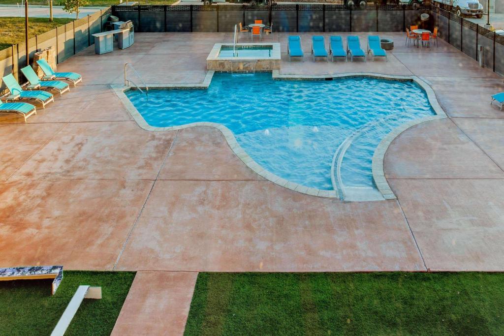 uma grande piscina com cadeiras em La Quinta by Wyndham San Antonio Alamo City em San Antonio