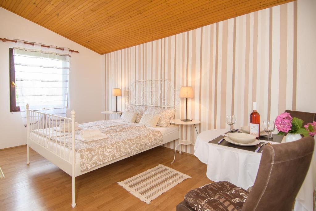 a white bedroom with a bed and a table with a table sidx sidx at Apartments & Rooms Darrer in Poreč