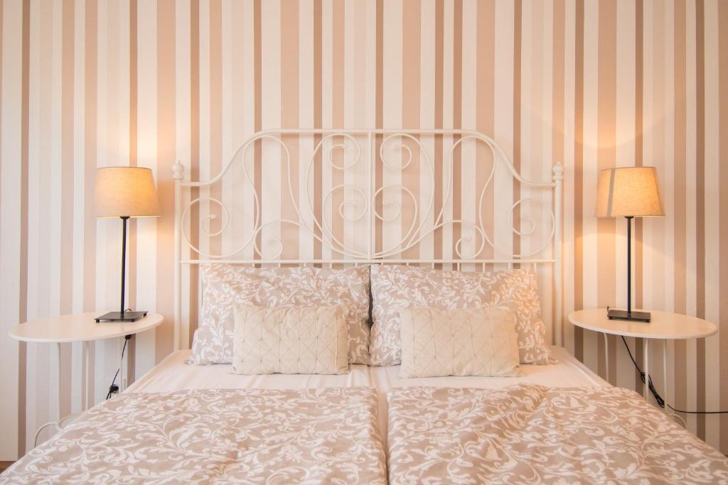 a bedroom with a white bed with two lamps at Apartments & Rooms Darrer in Poreč