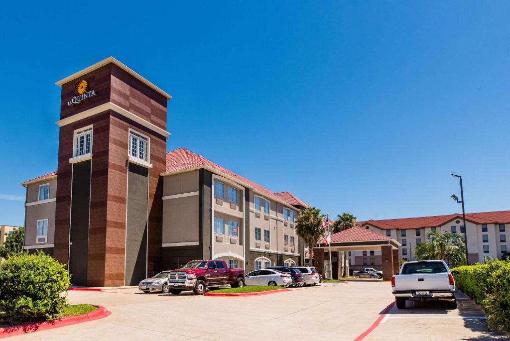 a hotel building with cars parked in a parking lot at La Quinta by Wyndham Houston/Clear Lake-NASA in Webster