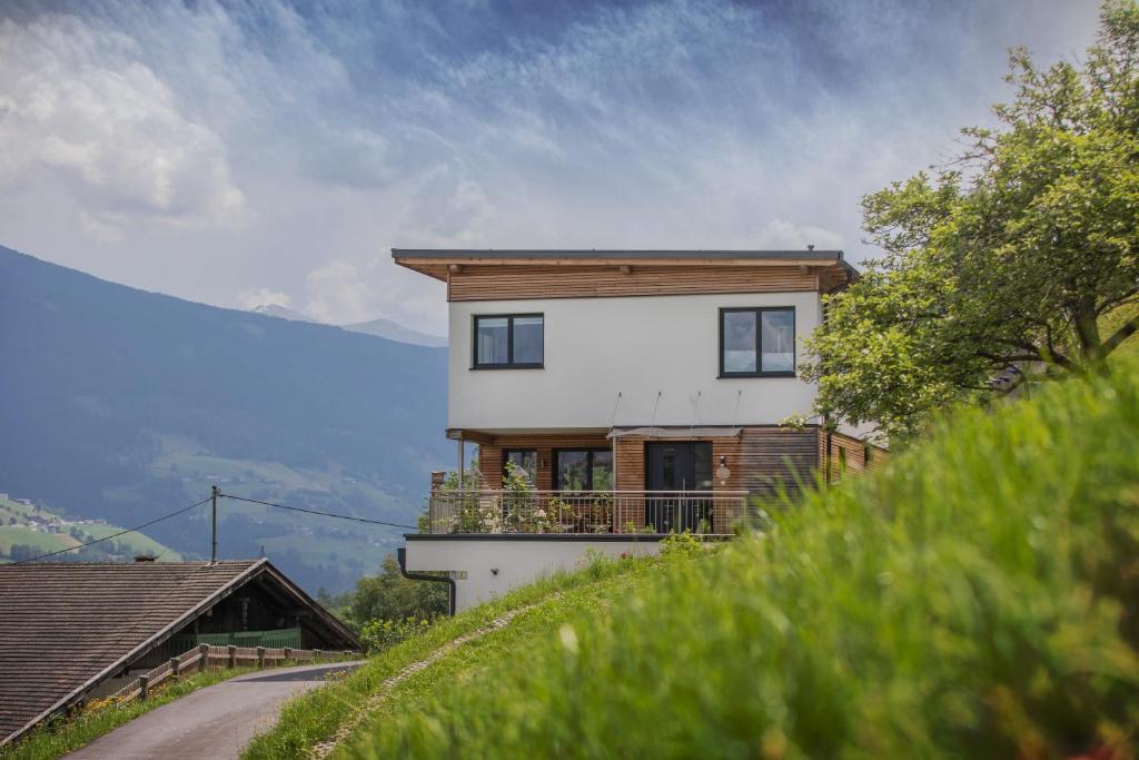 a white house with a balcony on a hill at Appartement PIA in Schönberg im Stubaital