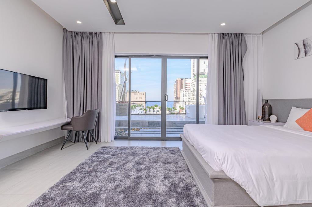 峴港的住宿－Cocochine Da Nang，一间卧室设有一张床、一台电视和一个窗口。