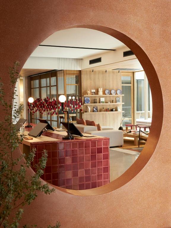 A shared hotel lounge and work area viewed through a circular opening.