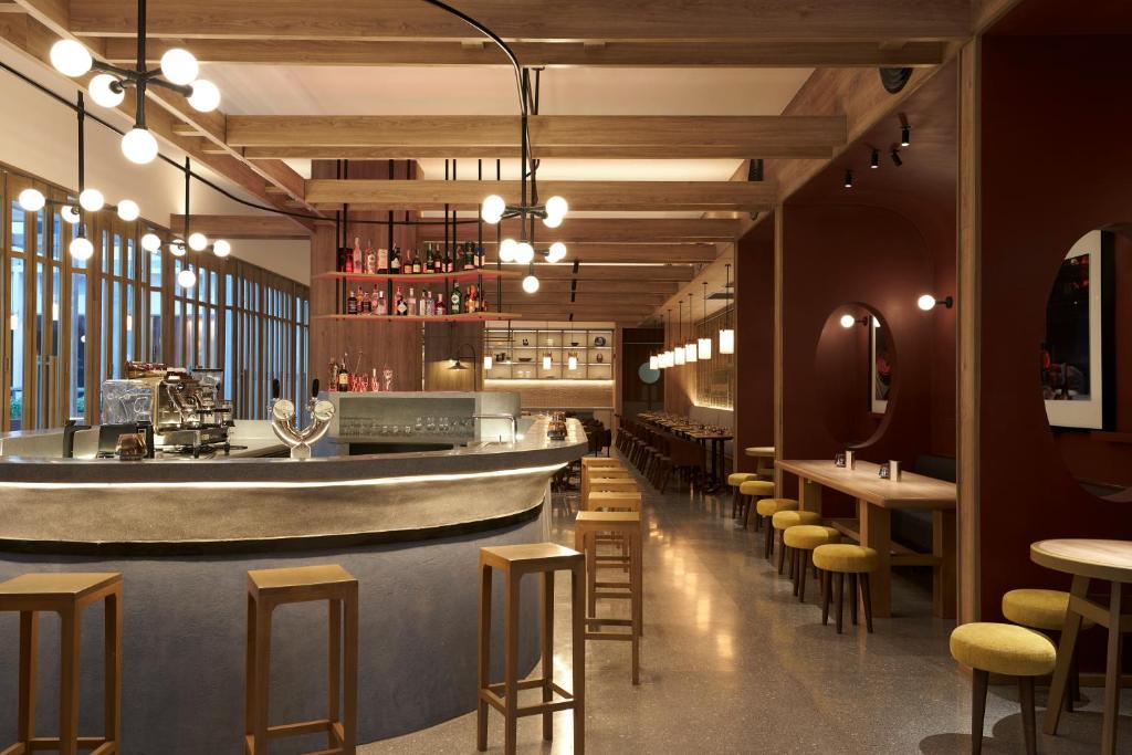 A bar and dining room with a long counter, stools, and warm timber detailing.