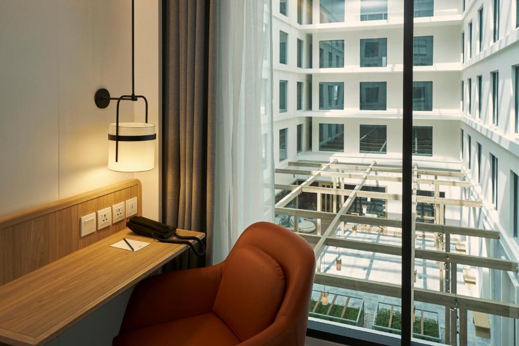 A narrow desk sits beside a large window overlooking the hotel’s internal courtyard.