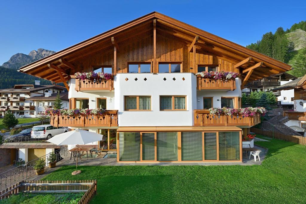 a house in the mountains with a balcony at Apartments Burvel in Selva