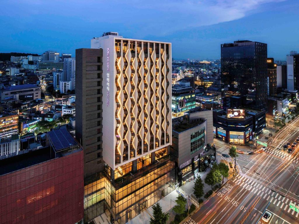 首尔Mercure Ambassador Seoul Hongdae的夜晚城市中的高楼