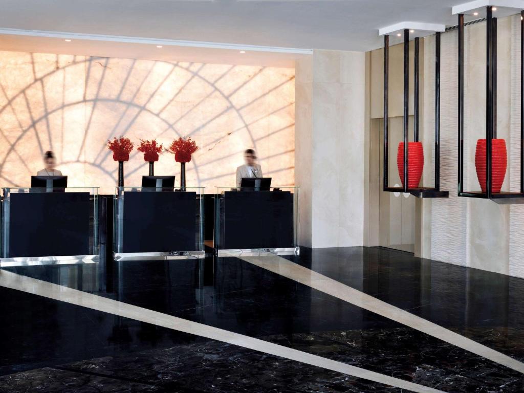 a lobby with people sitting at desks in a building at Mövenpick Hotel Apartments Downtown Dubai in Dubai