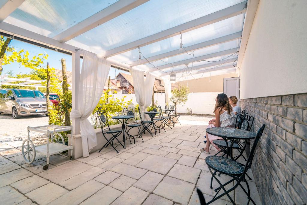 two women sitting at tables on a patio at Pumpion in Valtice