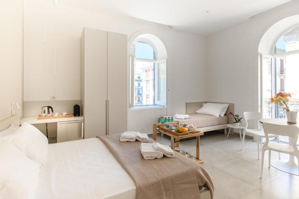 Lux Caracciolo في نابولي: غرفة نوم بيضاء مع سرير وغرفة معيشة