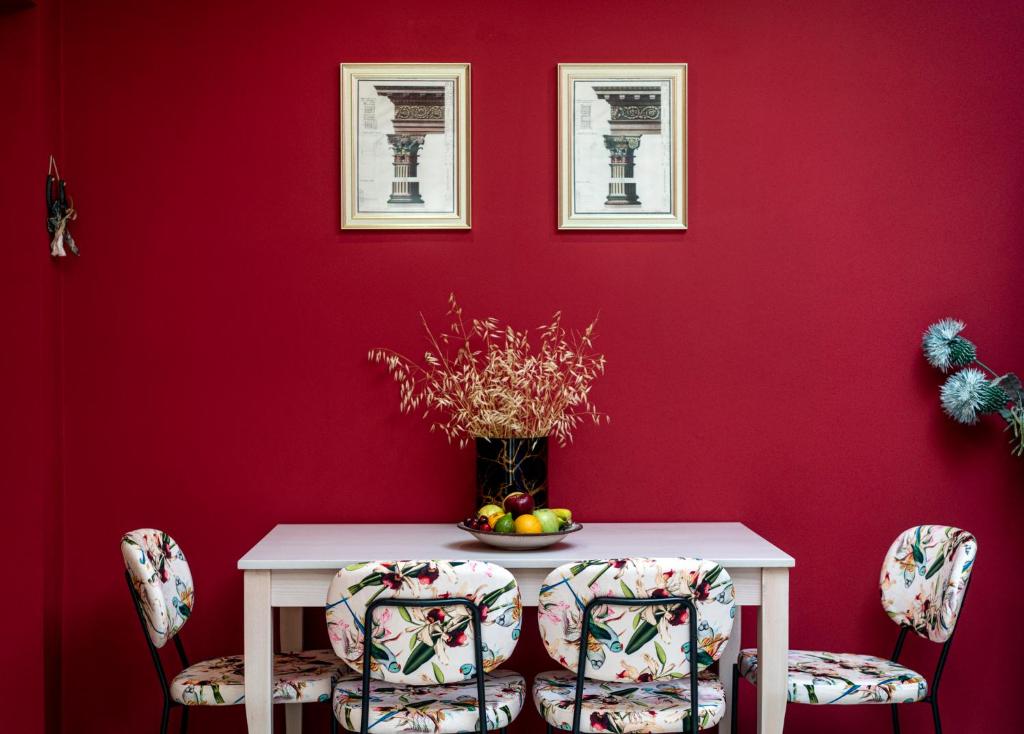 a red dining room with a white table and chairs at Casa de Colores en Corfu! in Corfu
