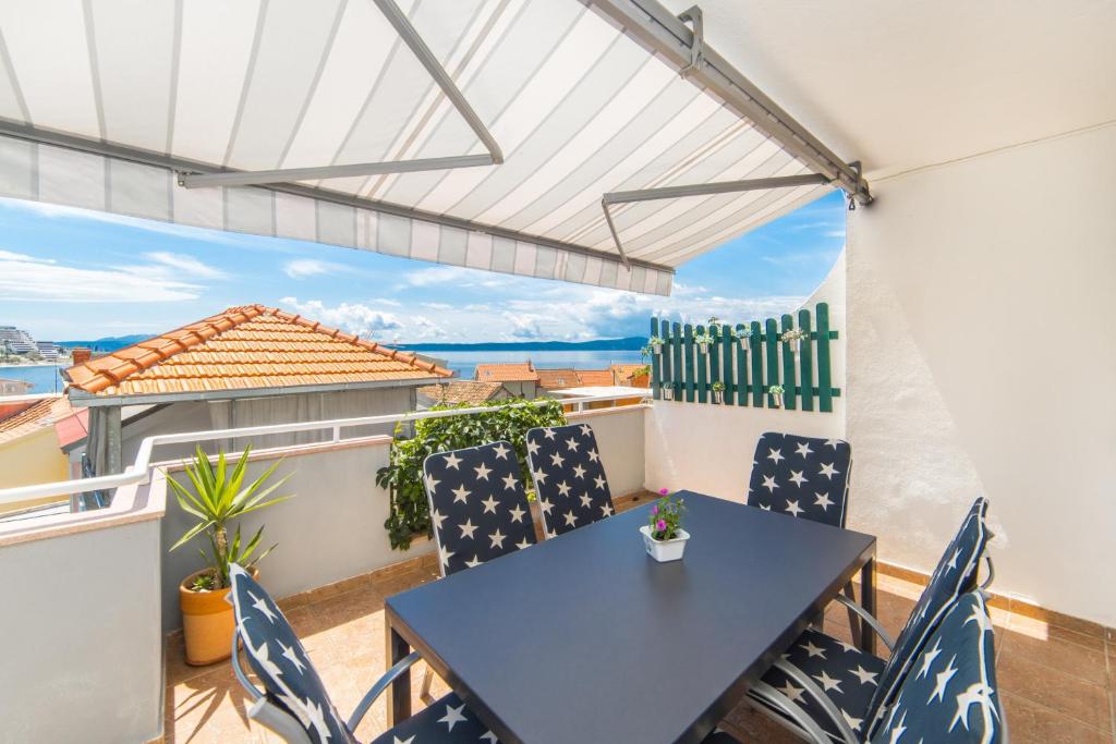 a patio with a table and chairs on a balcony at Apartmani Kala in Podgora