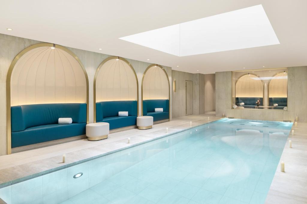 a swimming pool in a hotel room with blue furniture at Maison Albar Hotels - Le Vendome in Paris